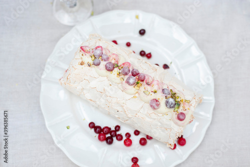 Meringue roll with crunberries and pistachios photo