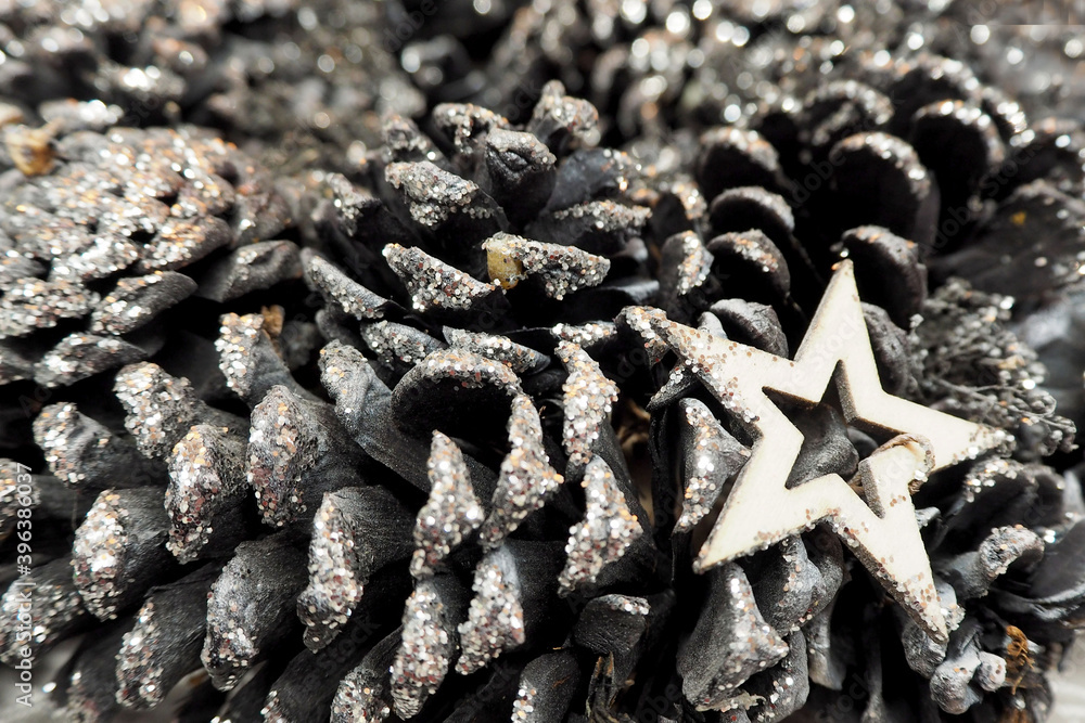 many cones are painted in a shiny gray color and a silver star . Christmas symbols