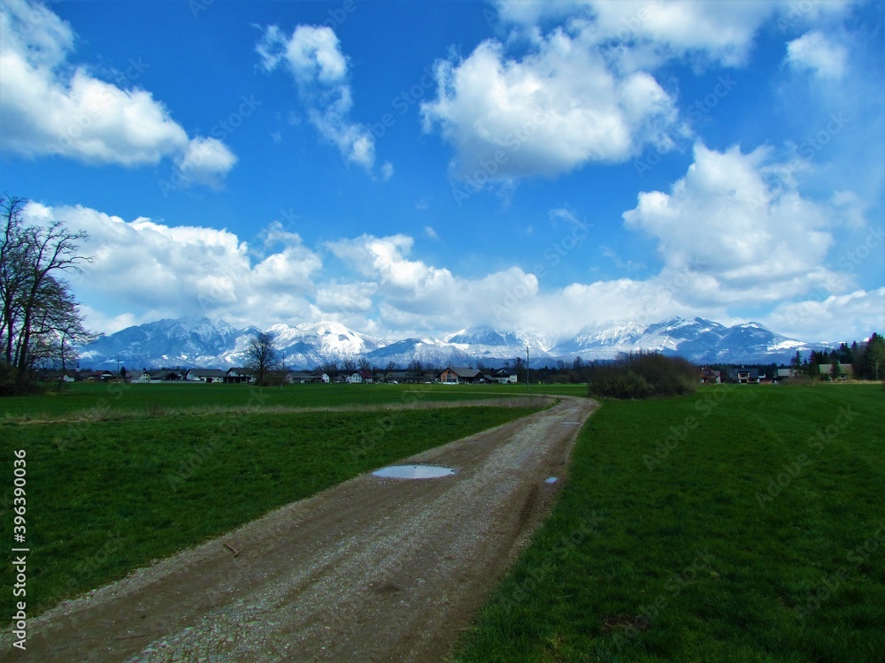 View of snow covered mountains of Kamnik-Savinja alps, Slovenia and fields in front