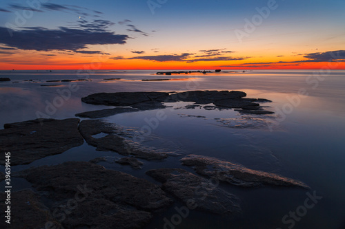 Rocks and stones in the shallow water. Baltic sea shoreline. Late summer sunset, Long exposure.