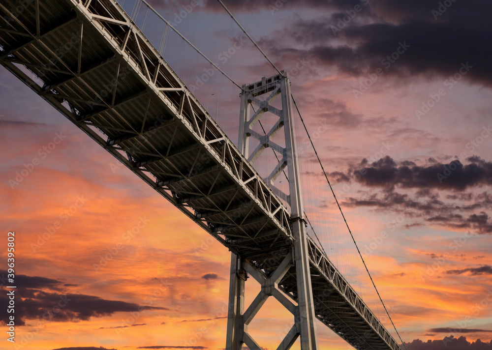 View below the Bay Bridge between San Francisco and Oakland California with sunset sky.