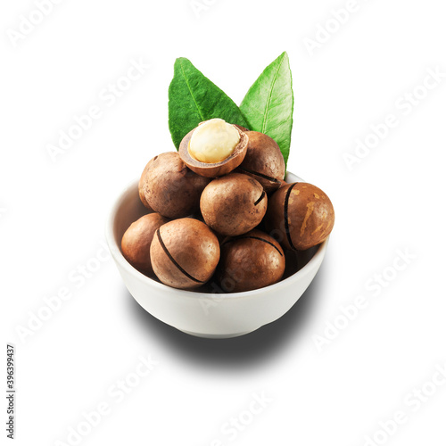 Macadamia nut in a white bowl against a white isolated background.