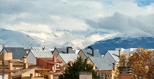 View of the rooftops of a residential area in Granada with the snow-capped Sierra Nevada mountains in the background © Miguel Ángel RM
