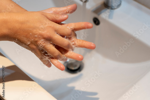 Woman washing hands with soap in sink.Hygiene concept ,preventive protection against germs, coronavirus or covid-19.