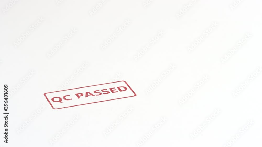 Putting red QC PASSED rubber stamp on the paper, close-up shot Putting red QC PASSED rubber stamp on the paper, close-up shot