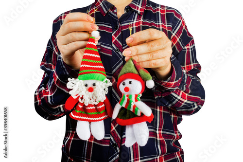 Isolated photo of a young girl in shirt holding decorative christmas figurine toys on white background.