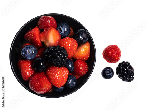 Detailed top view of 3 sorts of fruit in black round bowl, isolated on a white background