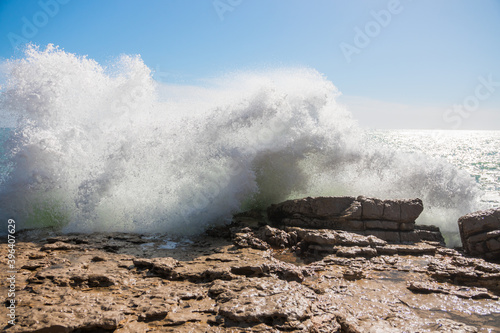 Beautiful waves crashing against the shore. Sunny summer day with a wild ocean. Impressive and spectacular photography. Red flag. Perfect desktop background.