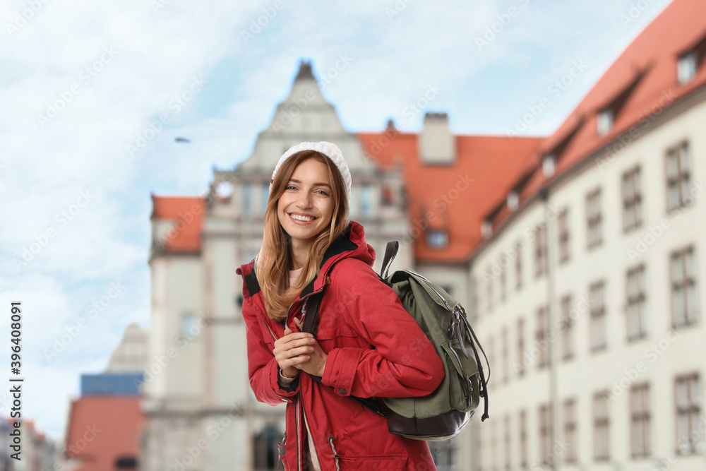 Happy traveler with backpack in foreign city during vacation