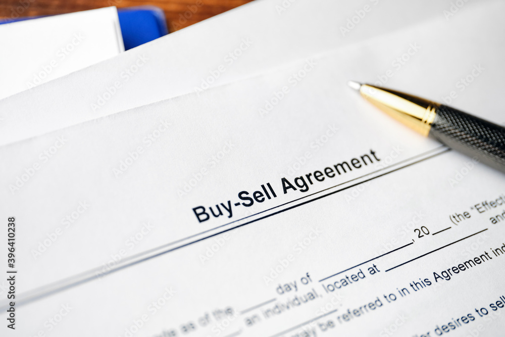 Legal document Buy-Sell Agreement on paper with pen Legal document Buy-Sell Agreement on paper with pen