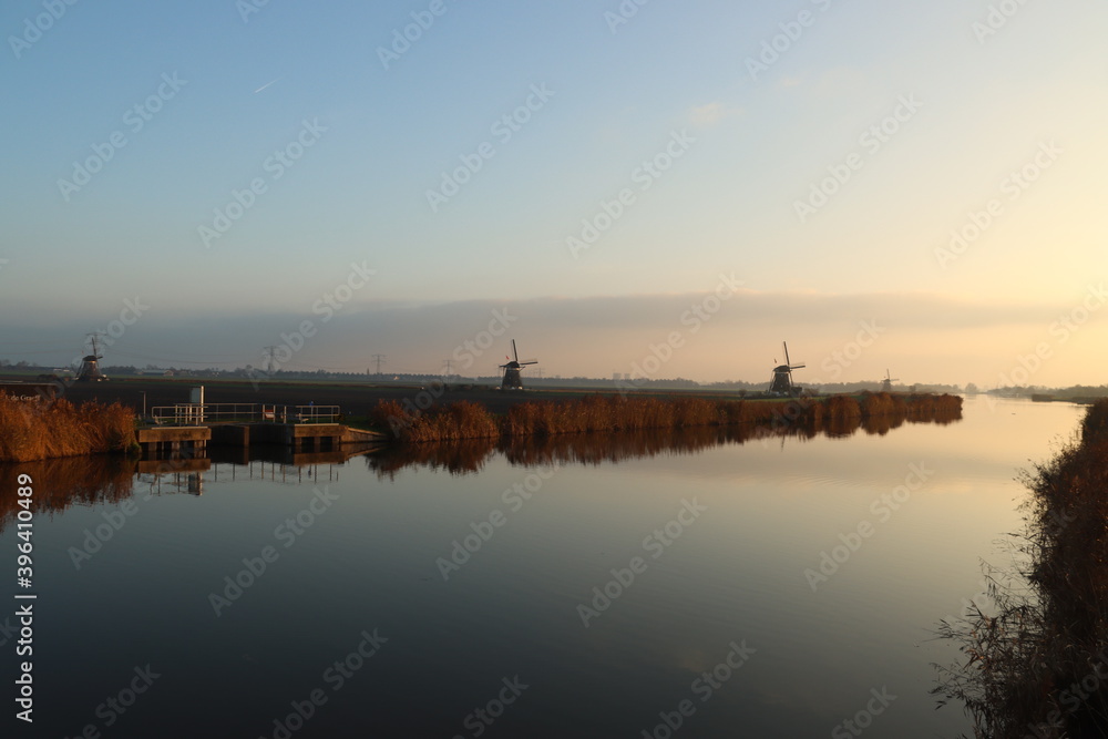 Sunset over the river Rotte in Zevenhuizen with windmills of the Molenviergang