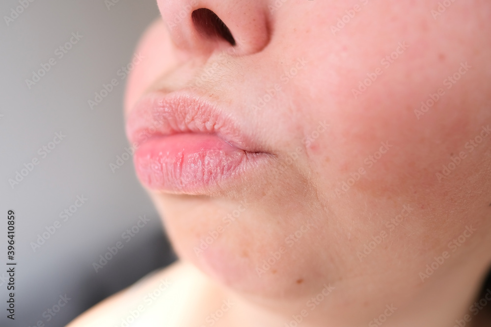 Fototapeta premium lips, mouth and chin of a middle-aged woman, part of the face close-up, fine wrinkles on the face, spots, cosmetology, plastic surgery and beauty concept, facial massage