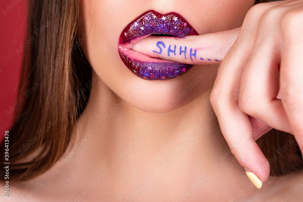 Shhh woman. Shh, Womens secrets. Female with finger in mouth. Closeup of young woman is showing a sign of silence with shhh written on the finger. Shhh woman. Shh, Womens secrets. Female with finger in mouth. Closeup of young woman is showing a sign of silence with shhh written on the finger.