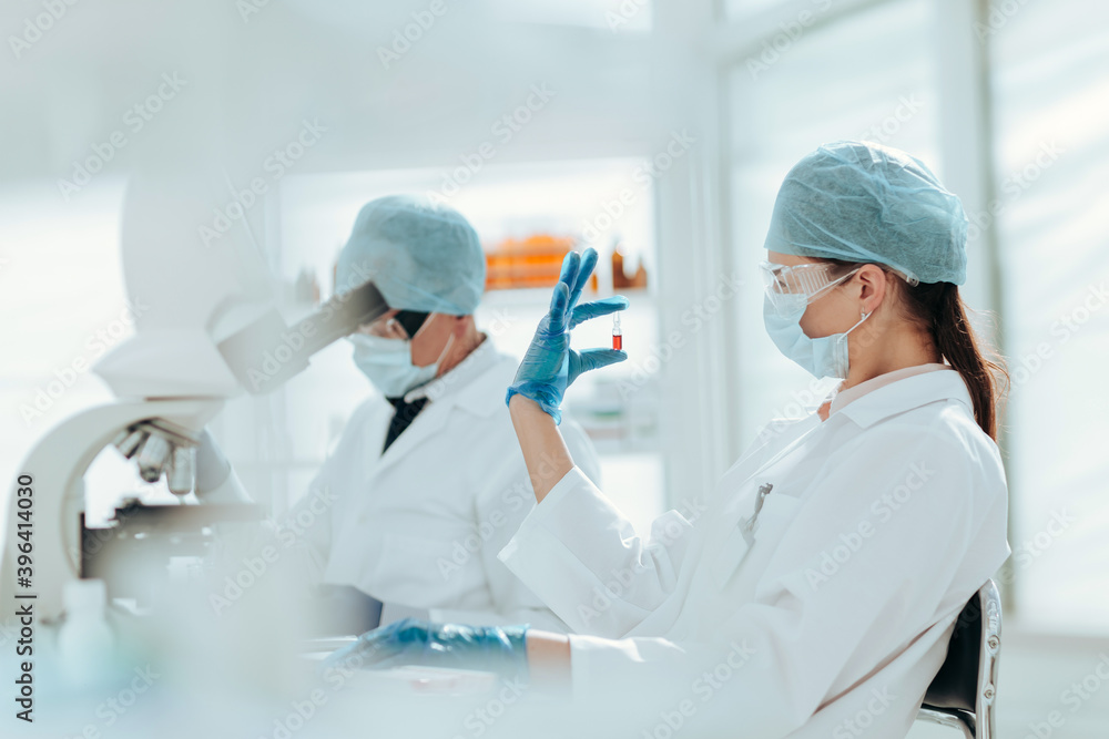 ampoule with a vaccine in the hands of a female scientist. ampoule with a vaccine in the hands of a female scientist.