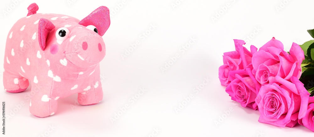 A toy plush pig covered with white hearts next to a bouquet of pink roses. A toy plush pig covered with white hearts next to a bouquet of pink roses.