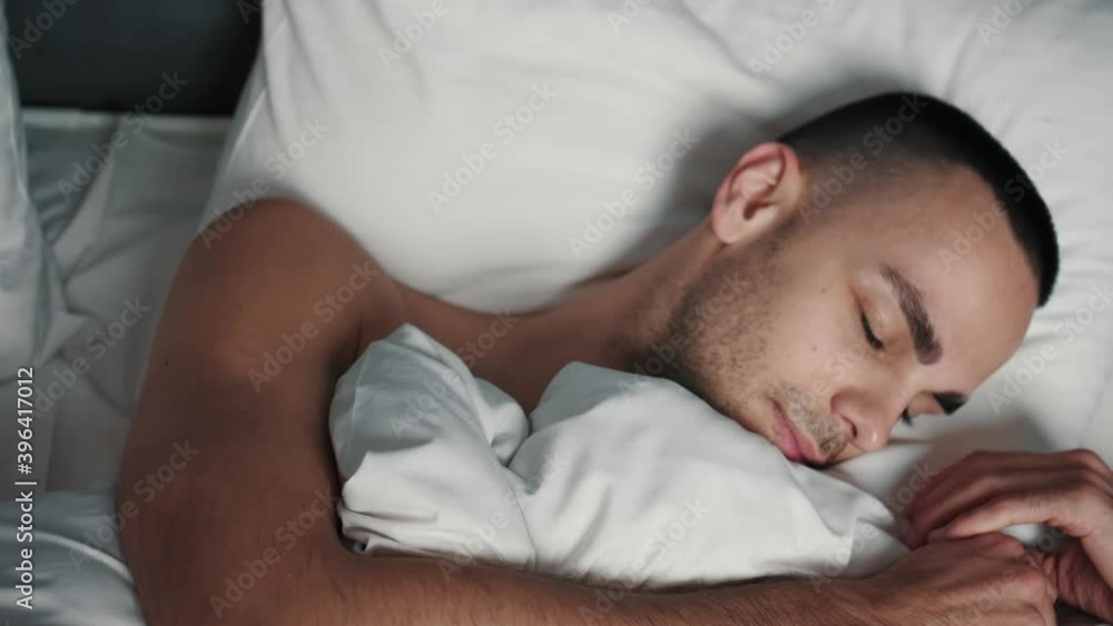 Happy smiling man sleeping peacefully on the bed. Adult Man going to sleep in bed, exhausting day, night rest. Happy smiling man sleeping peacefully on the bed. Adult Man going to sleep in bed, exhausting day, night rest.