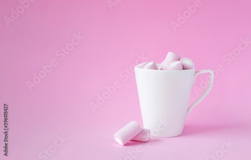 pink marshmallow in white cup on pink background. Christmas, mother's day, birthday card concept