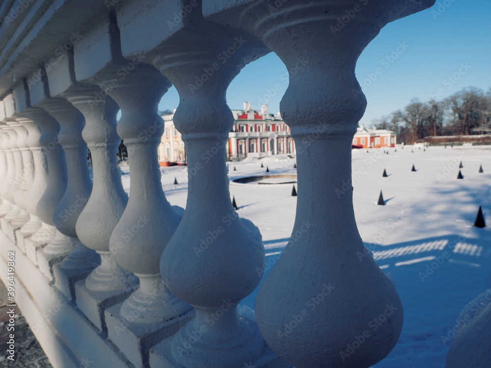 The snow-covered territory of the old mansion is visible through the white balusters
