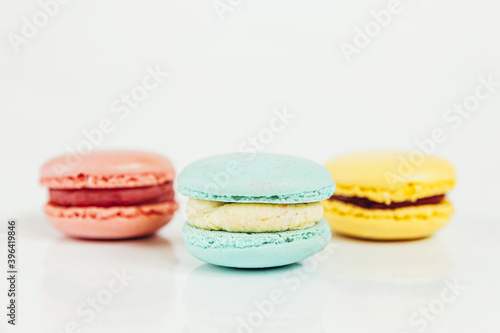 Sweet almond colorful pastel pink blue yellow macaron or macaroon dessert cake isolated on white background. French sweet cookie. Minimal food bakery concept Copy space