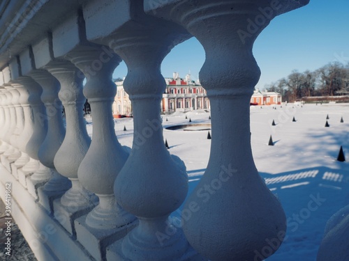 The snow-covered territory of the old mansion is visible through the white balusters
