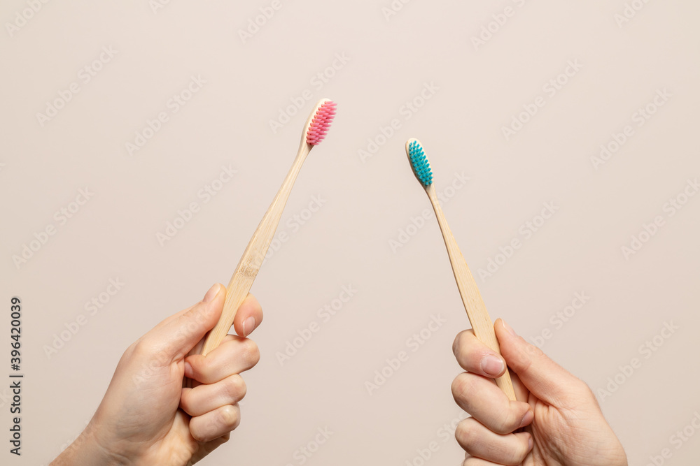 Pink and blue bamboo toothbrush in hands Pink and blue bamboo toothbrush in hands