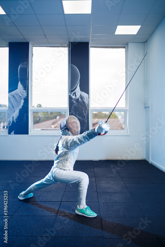 Child in a fencing costume and mask, with a sword, fencing school © Дмитрий Ткачук