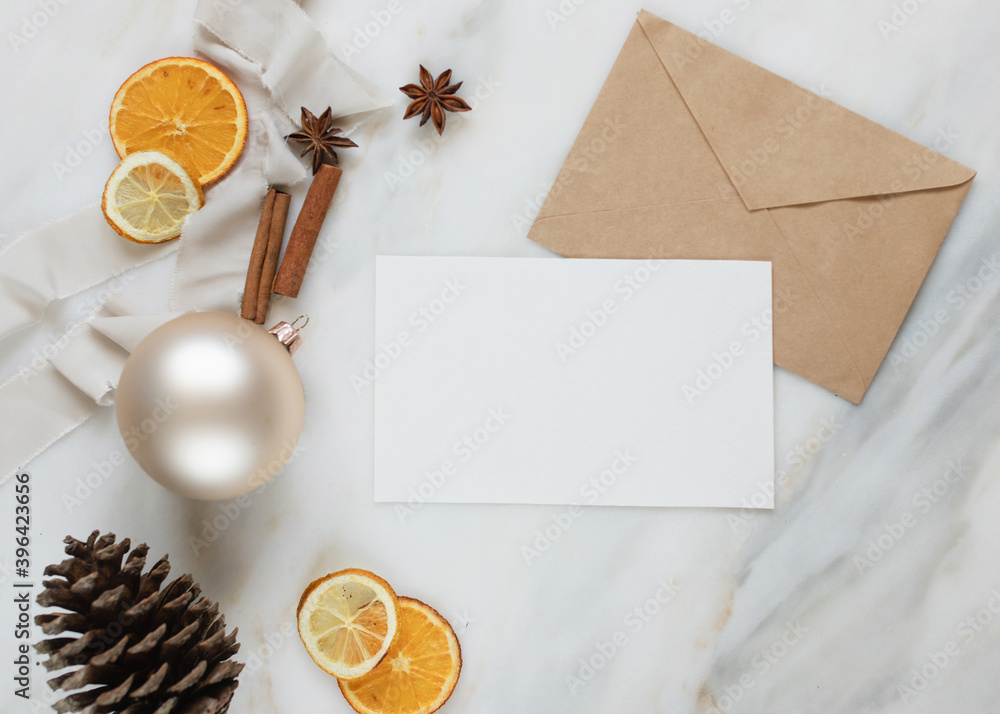 Christmas corner border on marble surface with blank postcard with copy space, flat lay, dried oranges, Christmas balls, pine cones, cinnamon sticks, anise stars, ribbons. Christmas corner border on marble surface with blank postcard with copy space, flat lay, dried oranges, Christmas balls, pine cones, cinnamon sticks, anise stars, ribbons.