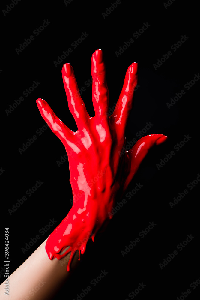 partial of painted hand with red dripping paint isolated on black partial of painted hand with red dripping paint isolated on black