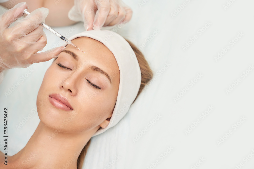 Near eye injection at spa salon. Doctor hands. Closeup. High quality. Pretty female patient. Beauty treatment. Healthy skin procedure. Young woman face. Crows feet wrinkle. Plasmolifting rejuvenation