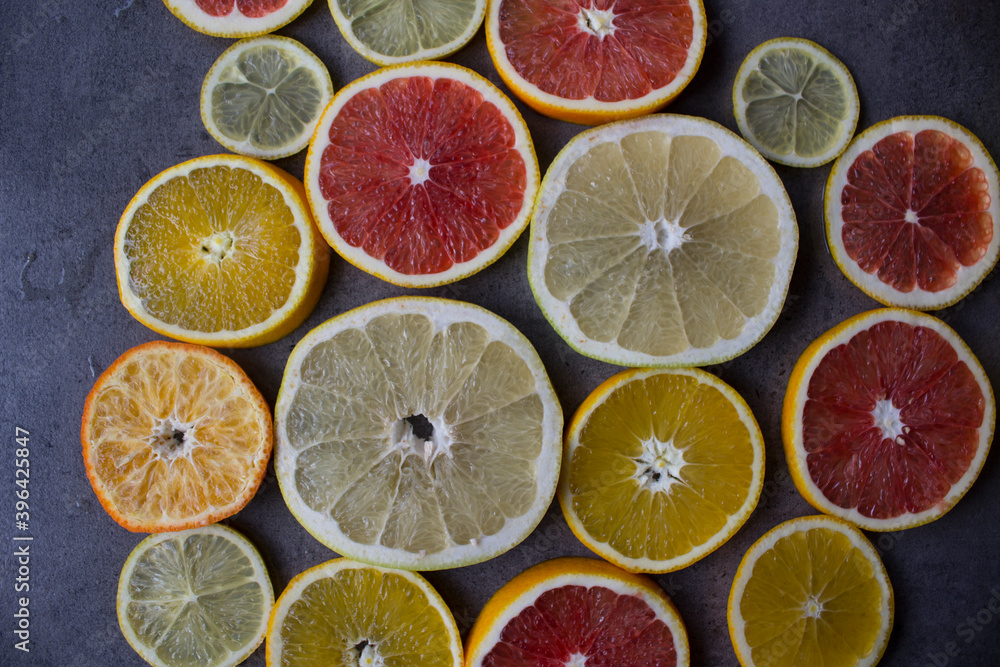Juicy citrus fruits slices top view photo. Colorful background made of fresh oranges, grapefruits, limes and lemons. Healthy eating concept. Juicy citrus fruits slices top view photo. Colorful background made of fresh oranges, grapefruits, limes and lemons. Healthy eating concept.