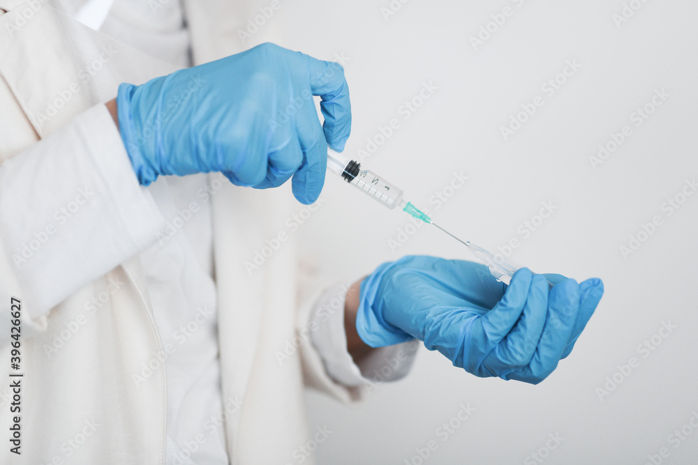Female doctor wearing protective equipment with a syringe - covid-19 health concept Female doctor wearing protective equipment with a syringe - covid-19 health concept