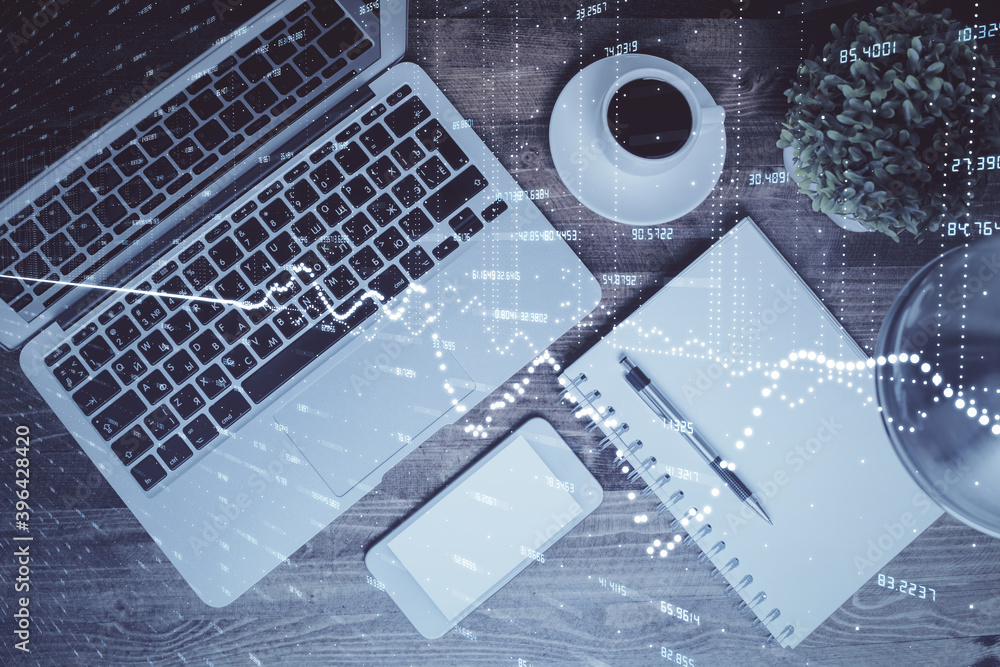 Financial market graph and top view computer on the desktop background. Double exposure. Investment concept. Financial market graph and top view computer on the desktop background. Double exposure. Investment concept.