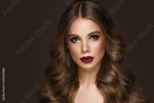 Beautiful sexy woman with classic make-up, fashion hair and red lips. Beauty face. Photo taken in the studio.