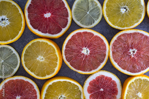 Background made of ripe juicy oranges slices. Top view photo of different types of citrus. 