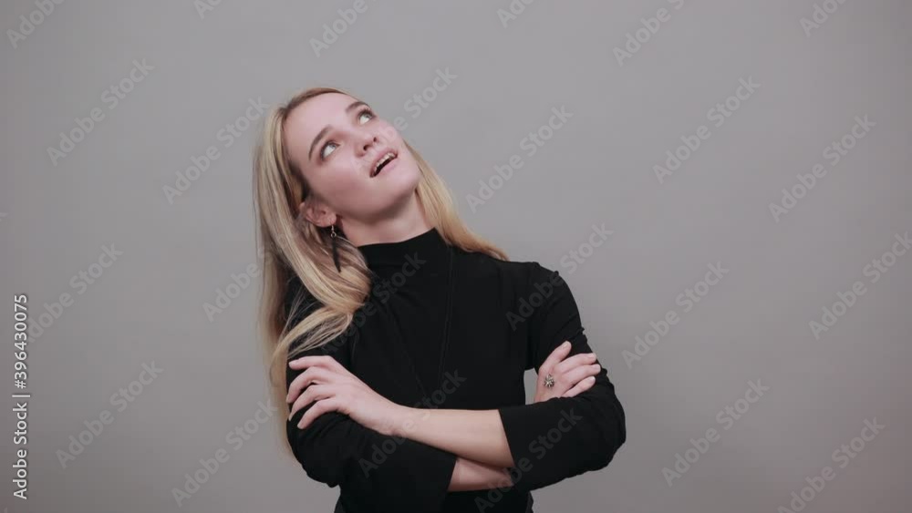 Arms crossed, laughing looking at camera with big grin. Happy face smiling. Positive person. Young attractive woman, dressed black sweater with green eyes, blonde hair, background Arms crossed, laughing looking at camera with big grin. Happy face smiling. Positive person. Young attractive woman, dressed black sweater with green eyes, blonde hair, background