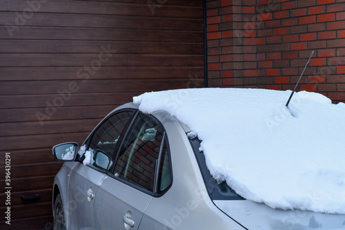 Detail of a car parked near the garage door in winter. Selective focus.