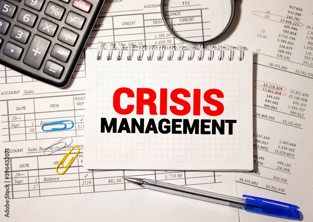 Word text CRISIS MANAGEMENT . Business concept with chart, dollars and office tools Word text CRISIS MANAGEMENT . Business concept with chart, dollars and office tools