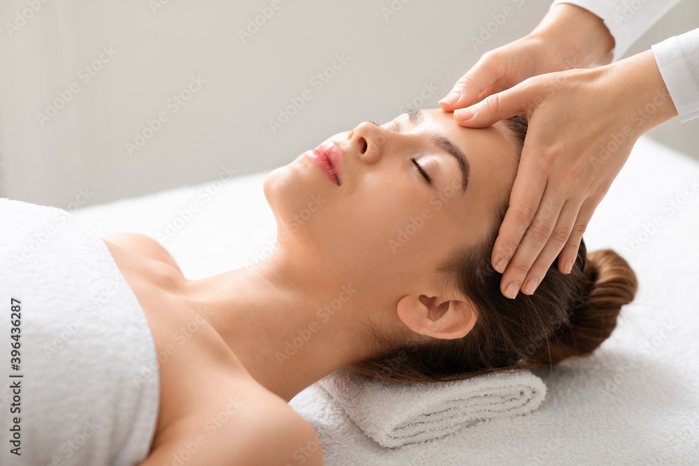 Acupressure face massage for attractive young woman at thai spa