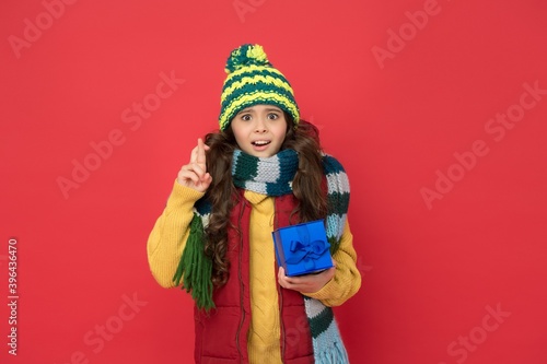 stylish child in knitwear care health in cold season holding present box for new year holiday, winter sales