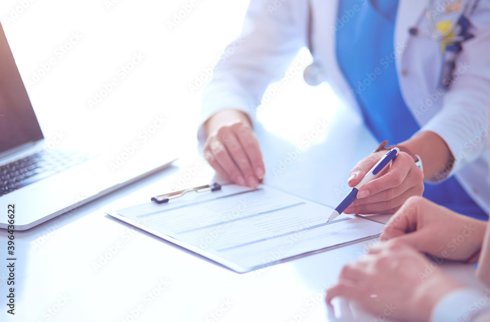 Doctor and patient couple are discussing something,sitting on the desk Doctor and patient couple are discussing something,sitting on the desk