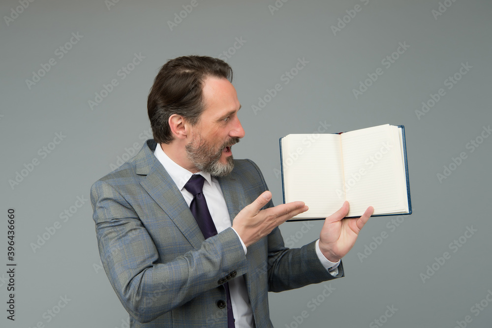 Surprised bearded man in formal business suit show open book for information, copy space Surprised bearded man in formal business suit show open book for information, copy space