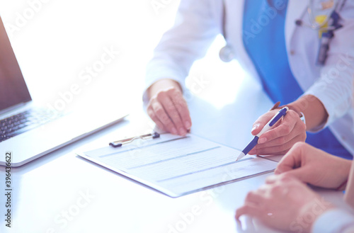 Doctor and patient couple are discussing something,sitting on the desk