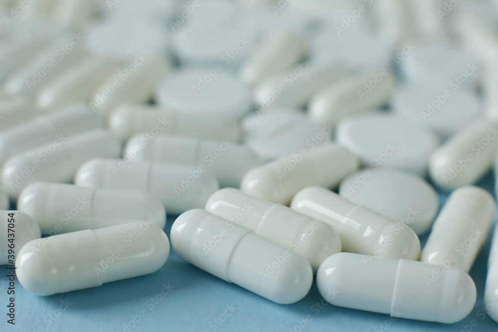 White pills on blue background White pills on blue background