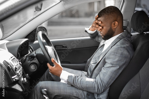 Tired black businessman having troubles at work, sitting in car © Prostock-studio