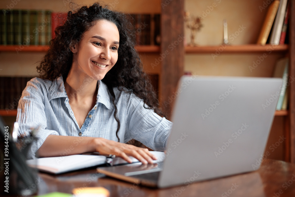 Woman sitting at desk, using computer and typing on keyboard Woman sitting at desk, using computer and typing on keyboard