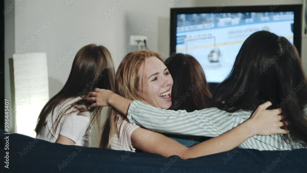 Excited millenials cheering for team sitting in living room. Backshot group of teens watching hockey match on tv celebrating goal. Concept of leisure, lifestyle, spending time together, victory. Excited millenials cheering for team sitting in living room. Backshot group of teens watching hockey match on tv celebrating goal. Concept of leisure, lifestyle, spending time together, victory.
