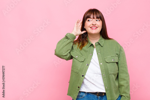 overweight woman smiling, looking curiously to the side, trying to listen to gossip or overhearing a secret photo