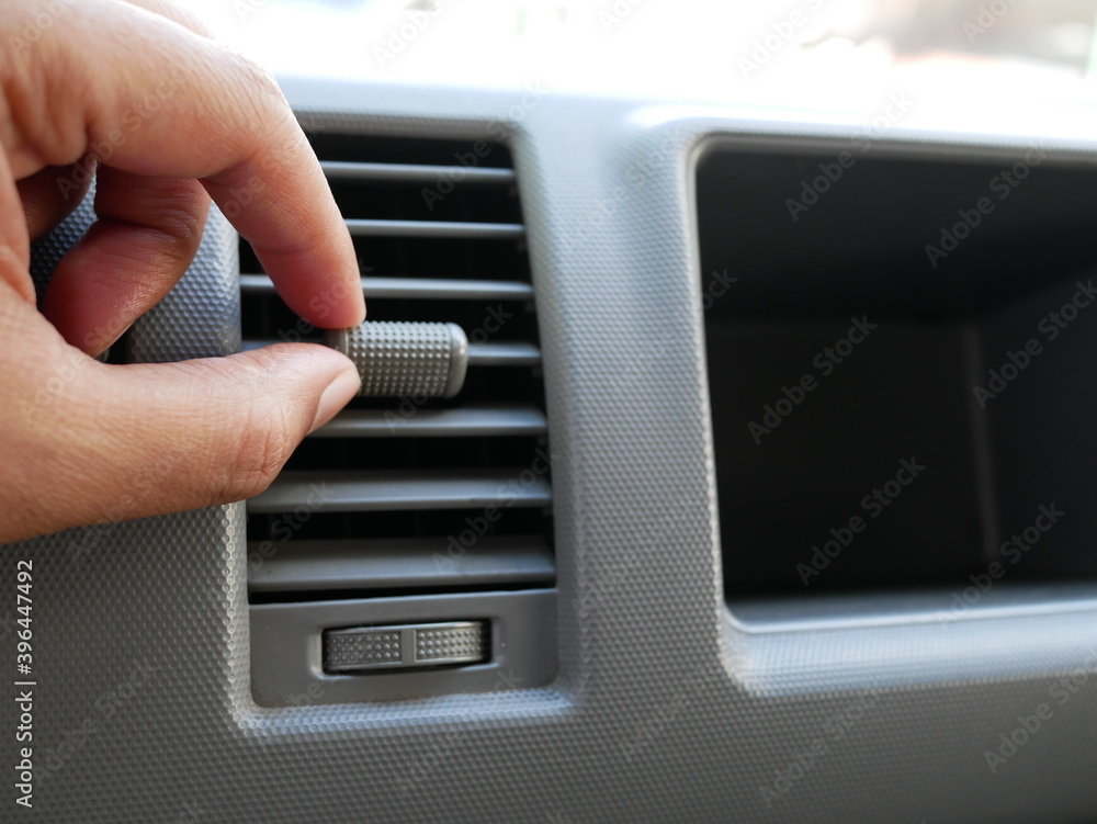 hand adjusting on car air conditioning button.