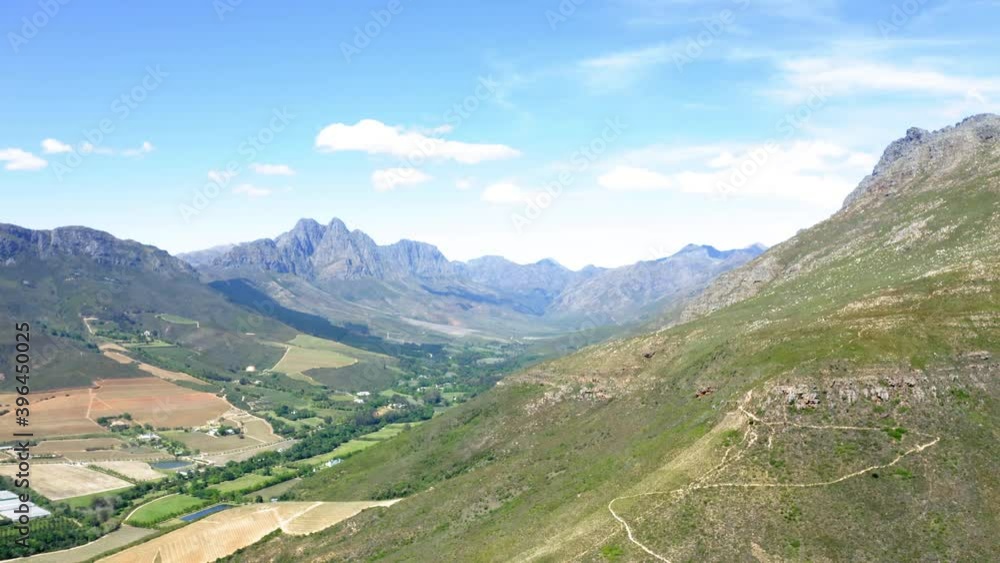 Aerial drone, green mountain slope with steep hiking trail from valley of farm land and forest, Stellenbosch, Hottentots Holland, Jonkershoek Aerial drone, green mountain slope with steep hiking trail from valley of farm land and forest, Stellenbosch, Hottentots Holland, Jonkershoek