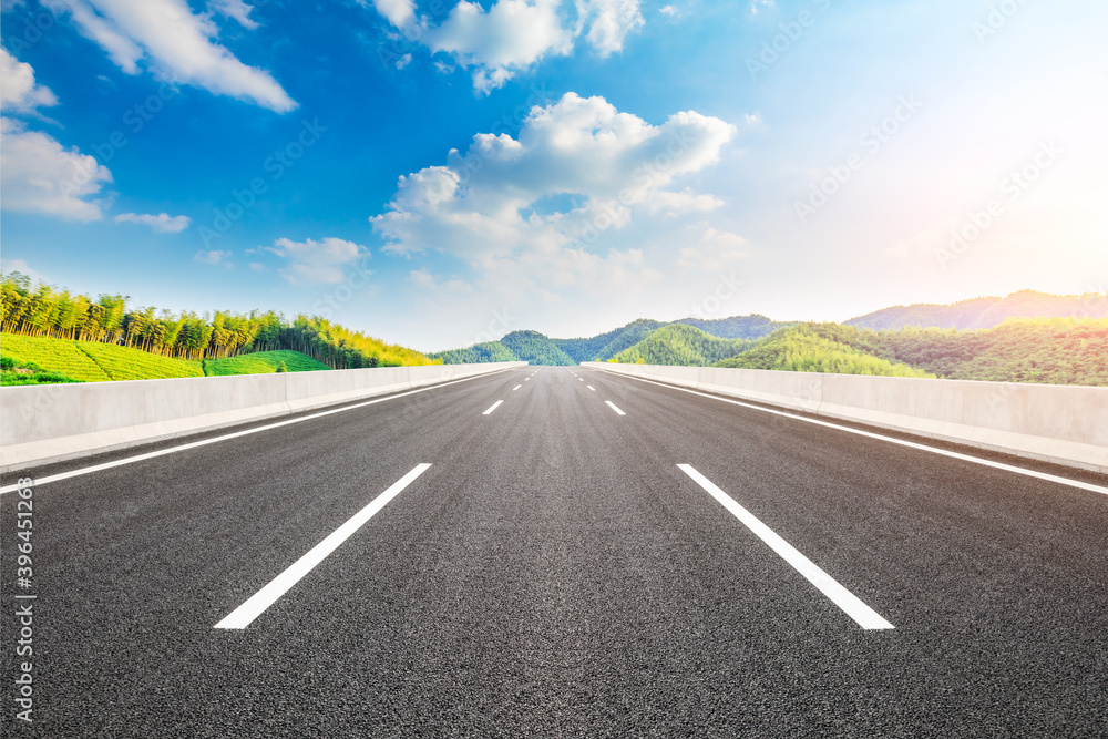 Naklejka premium Asphalt road and green mountain with bamboo forest natural landscape.